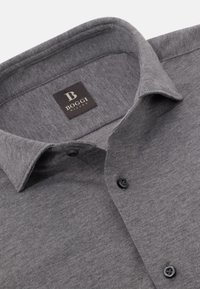 Graues Hemd mit Knopfverschluss aus strukturiertem Stoff, mit spitzem Kragen und schwarzen Knöpfen. Das Etikett trägt die Aufschrift "Boggi Milano."