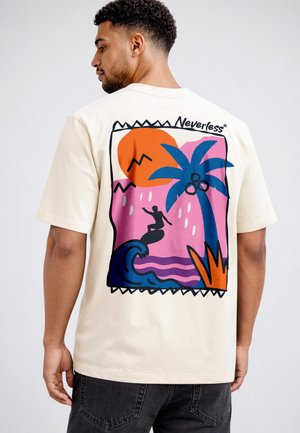 Man wearing cream t-shirt with colorful graphic of surfer, palm tree, and orange sun, labeled "Neverless" on the back.