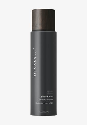 Wysoka cylindryczna puszka czarnego pianki do golenia z pokrywką o fakturze drewna, oznaczona „Rituals homme cedarwood + hydra complex, 200 ml.”