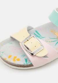Färgglada sandaler med ett flerfärgat blommönster på en grå bas, med gula, mintgröna och rosa remmar, samt en silverfärgad spänne.