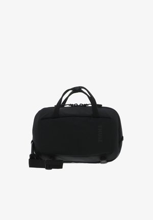 Sac de transport noir compact Thule avec double poignées, compartiment principal zippé et bandoulière ajustable.