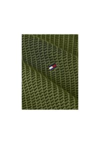 Grüner Textilstoff mit diagonaler Struktur, auf einer Seite mit einem kleinen gestickten Logo in Rot, Weiß und Blau.