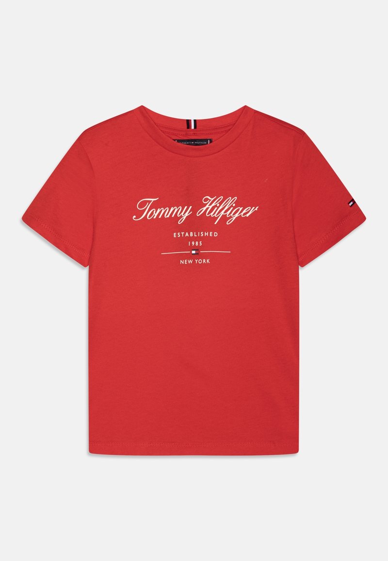 T-shirt in cotone rosso con logo "Tommy Hilfiger" in bianco, con testo aggiuntivo sotto. Maniche corte e colletto rotondo.