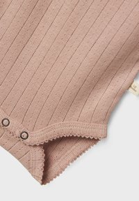 Ljusrosa ribbad bodysuit i mjukt tyg, med dekorativ sömnad, tryckknappar och små perforeringar genom hela designen.