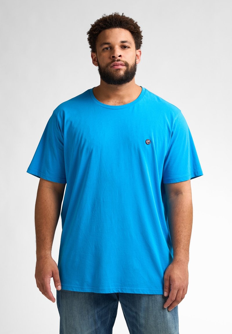 Tricou scurt, de culoare albastră, din bumbac, cu guler rotund și un mic logo negru pe piept. Textură fină, croială lejeră.