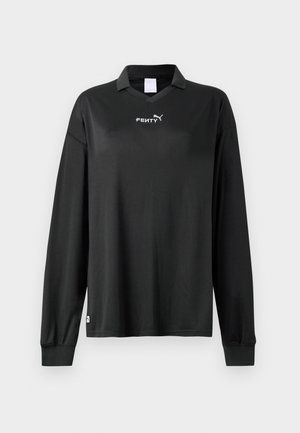 Melnas garās piedurknes polo krekls ar apkakli, ribotām aprocēm un baltu "FENTY" un Puma logo uz krūtīm.