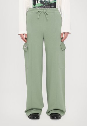 Green wide-leg sweatpants made of soft fabric, featuring a drawstring waistband and side cargo pockets with flap closures.