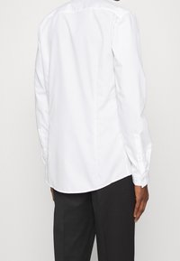 Witte lange mouwen shirt met een puntige kraag, knoopsluiting bij de manchetten en een rechte snit, gemaakt van gladde katoenstof.