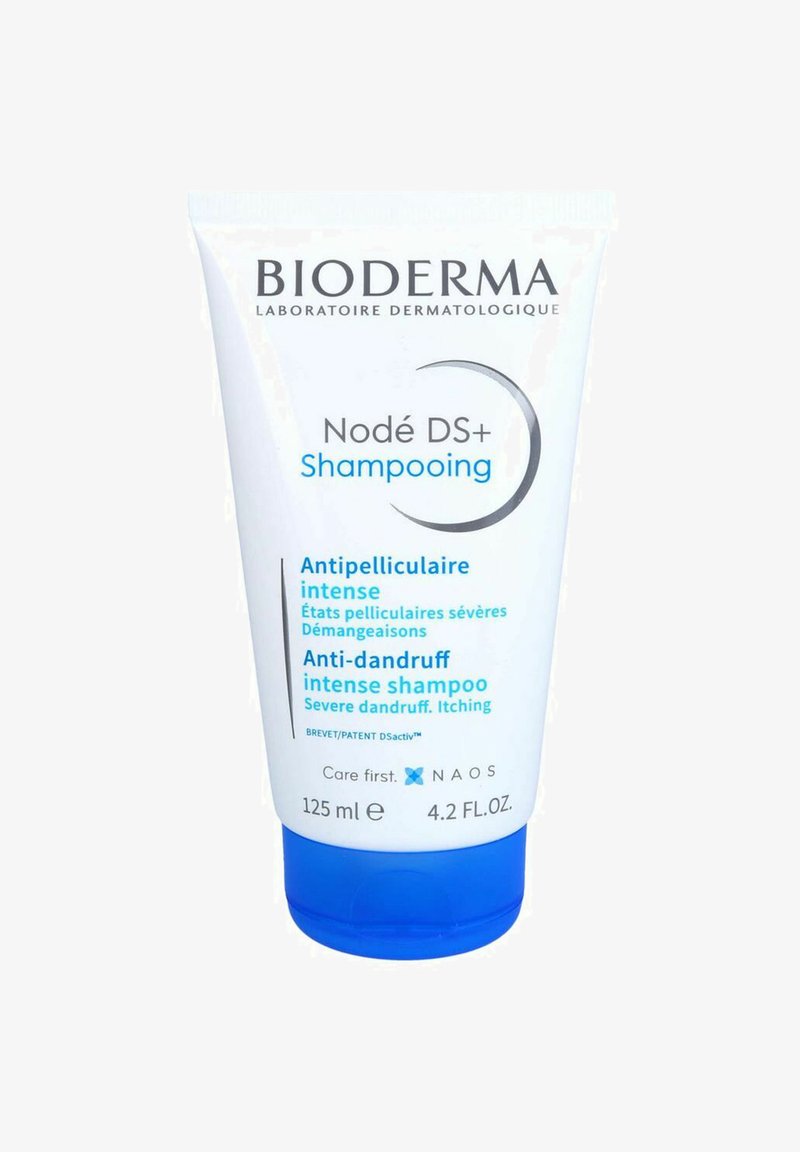 Bioderma Nodé DS+ anti-dandruff shampoo in a white tube with blue cap, featuring blue and black text highlighting key benefits and usage instructions.