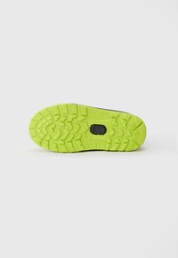 Suela de goma verde con patrones de tracción, mostrando una forma redondeada y una superficie texturizada; parte de un diseño de calzado.