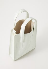 Krokodilpräge, hellgrüne Handtasche mit kurzen Tragegriffen, einer strukturierten Form und einem kontrastierenden beige Innenfutter. Mit Logo-Detail.