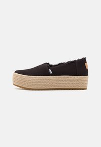 Chaussure slip-on en tissu noir avec des bords effiloch�és, semelle en jute et caoutchouc ; dotée d'une discrète étiquette de logo.