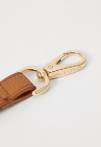 Brunt läderband med guldfärgat metallkarbinhake. Har präglat "Valentino"-logotyp på metallbeslaget. Strukturerat läder ger visuellt intresse.