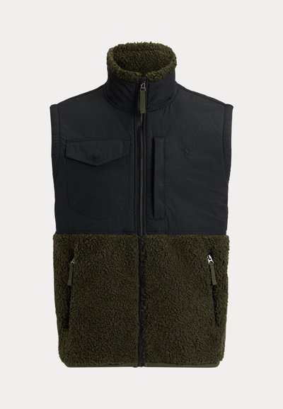 Vest med en svart, glatt overdel og en olivengrønn, teksturert fleece-nederdel. Har glidelås, stående krage og flere lommer.