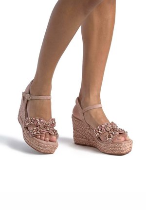 Wedge-Plateausandalen aus weichem rosa Wildleder mit einer geflochtenen Jute-Optik-Sohle. Mit einer großen Schleife verziert, die mit funkelnden Verzierungen geschmückt ist.