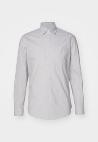 Camicia a maniche lunghe in tessuto bianco con pois neri, colletto classico, bottoni sul davanti e orlo dritto. Texture liscia.