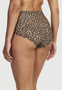 Höga leopardtryckade trosor i ett glänsande, mjukt tyg, med ett djärvt mönster av svarta fläckar på en beige bakgrund, med släta kanter.