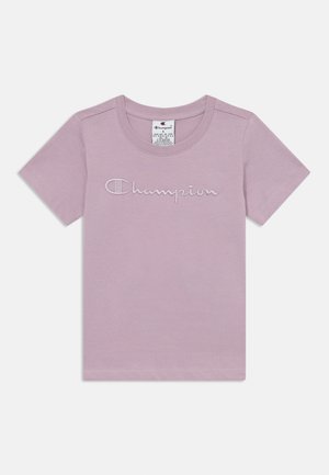 T-shirt lilas à manches courtes en coton, avec un logo "Champion" brodé sur la poitrine et un col rond classique.