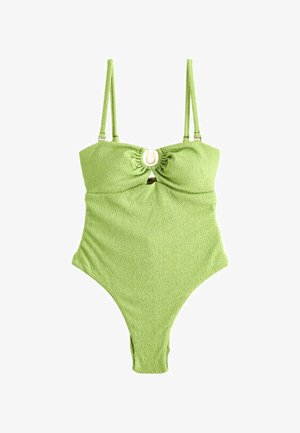 Zeleni jednocijelni kostim za kupanje s teksturiranim završetkom, koji ima podesive naramenice, nabran gornji dio i okrugli zlatni detalj u središtu.