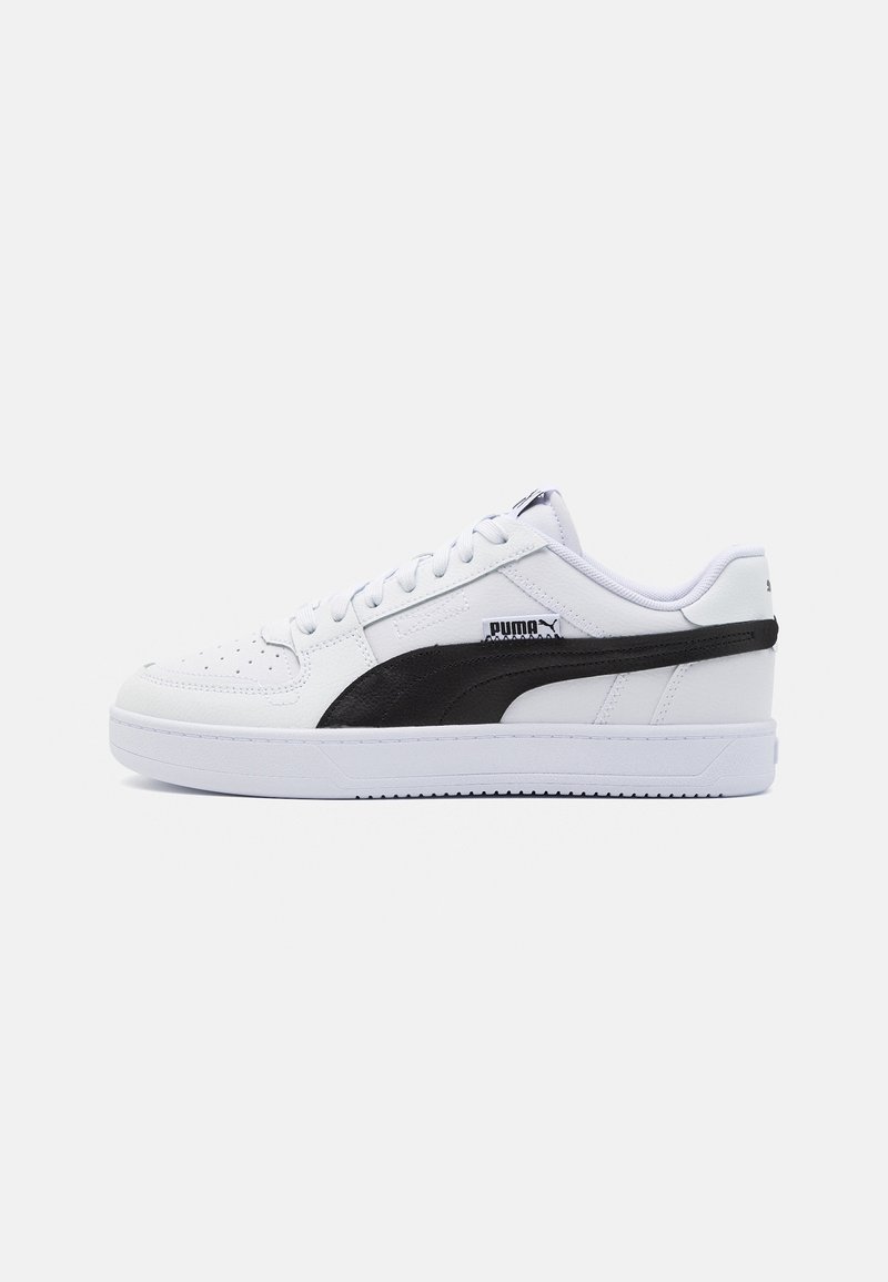 Basket basse blanche Puma avec bande latérale noire et lacets blancs, vue de profil sur fond uni.