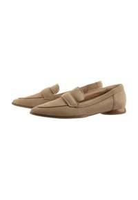 Mocassins en daim beige avec un bout arrondi, un talon en bois plat et une sangle arrondie sur le dessus. Texture lisse et design minimaliste.