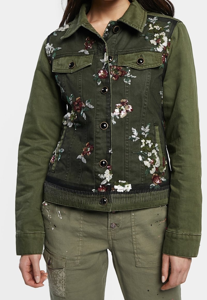 Grüne Jeansjacke mit floralem Pailletten-Stickerei, mit Kragen, vorderen Taschen und Druckknopfverschluss. Strukturierter Saum mit Akzenten.