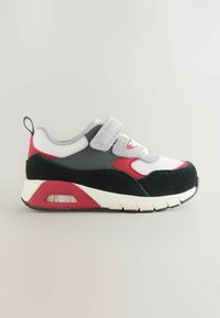 Børnesneakers med en kombination af hvid mesh, sort ruskind og gråt materiale, pyntet med røde detaljer. Velcro-rem og tekstureret sål.