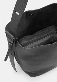 Borsa in pelle grigia con finitura testurizzata, apertura ampia e tracolla regolabile. Contiene una tasca interna liscia con zip.