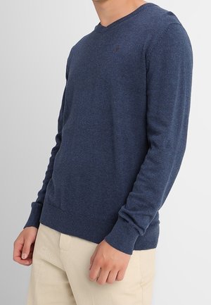 Pull bleu marine avec un col en V, des manches longues et des poignets côtelés. Fabriqué en tissu tricoté texturé, avec un petit logo sur la poitrine.