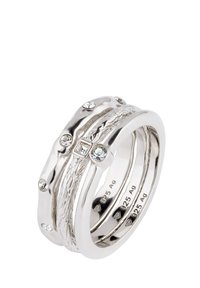 Kolm omavahel ühendatud hõbedast ringi, millel on tekstureeritud disain koos väikeste teemantide ja siledate poleeritud aktsentidega.