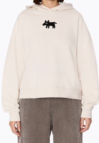 Felpa crema con maniche lunghe, caratterizzata da un design di un cane ricamato in nero sul petto. Realizzata in tessuto morbido con una vestibilità comoda.