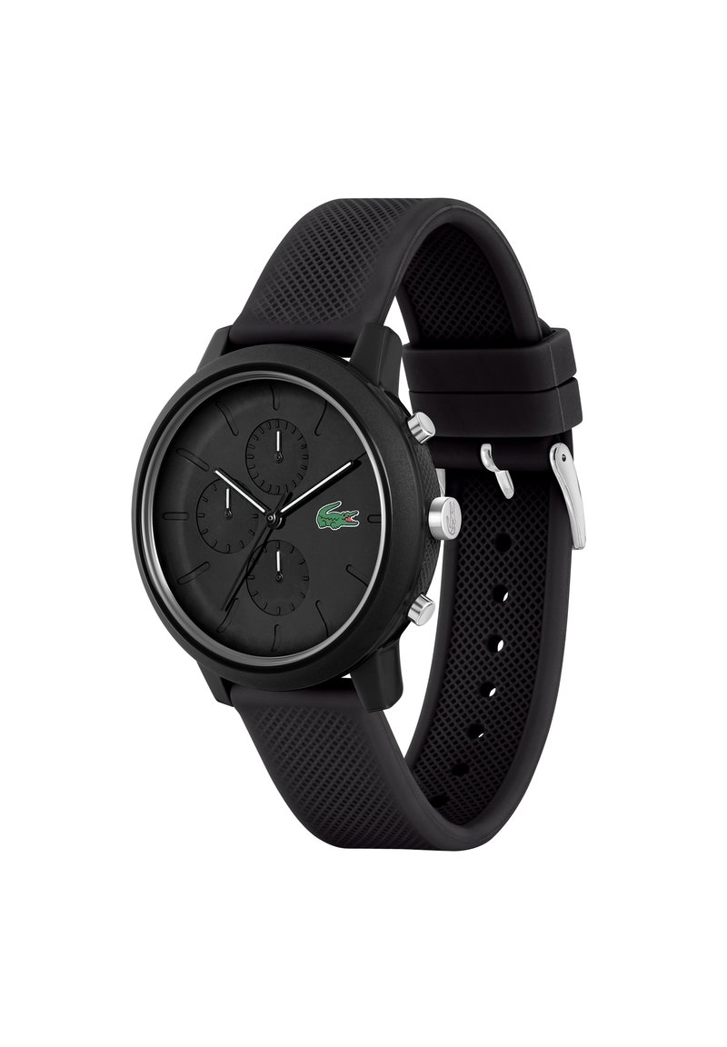 Montre en silicone noir avec un cadran rond comportant trois sous-cadrans, des accents argentés et le logo Lacoste. Bracelet texturé avec une boucle sécurisée.