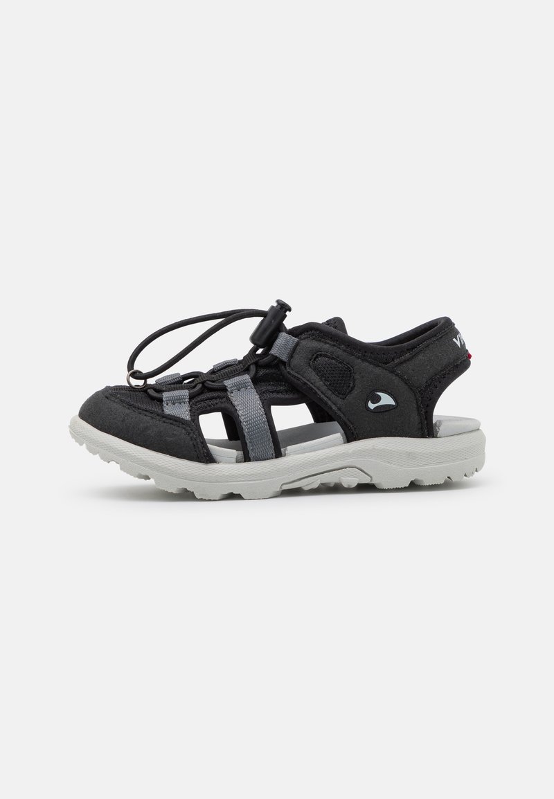 Czarne sandały z szarymi paskami i regulowanym sznurowaniem. Posiadają teksturowaną cholewkę oraz białą gumową podeszwę z wyraźnym wzorem bieżnika.