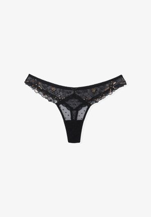 String noir en dentelle avec des détails floraux, un motif à pois et de petites paillettes. Bords festonnés et une taille en tissu doux.