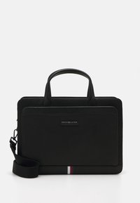 Sac pour ordinateur portable en cuir noir avec deux poignées supérieures, sangle réglable et détail de rayure horizontale en rouge, blanc et bleu en bas.