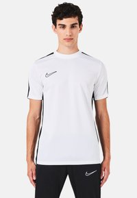 T-shirt atletico bianco a maniche corte con strisce laterali nere e logo Nike nero sul petto, realizzato in materiale leggero e traspirante.