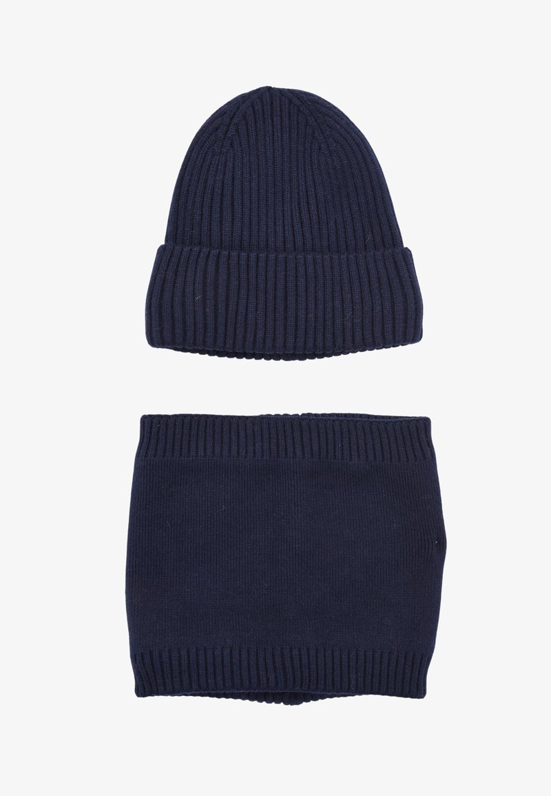 Berretto a maglia blu navy con texture a coste sulla parte superiore, abbinato a una sciarpa collo coordinata a coste. Entrambi gli articoli presentano un tessuto morbido e elastico.
