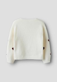 Hvid strikket sweater med en blød tekstur, prydet med rødbrune prikker på ærmerne og ribbet halsudskæring og kant.