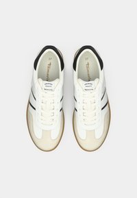 Λευκά και μπεζ χαμηλά sneakers με μαύρες ραφές στη φτέρνα, σχέδιο με κορδόνια και σόλα από καουτσούκ, σε άποψη από πάνω.