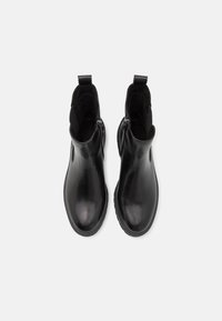 Stivaletti neri con caviglia in pelle liscia, dotati di un design slip-on con pannelli elastici laterali e cerniere. Fodera interna testurizzata e suola in gomma.