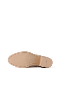 Suola di scarpa beige con gomma testurizzata per la presa, un leggero tacco e una finitura liscia. Punta arrotondata e caratteristiche di design minimal.