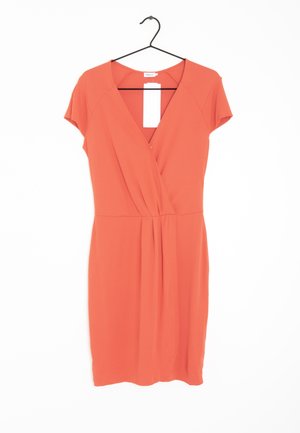 Vestido naranja de manga corta con escote en V, diseño envolvente y detalles fruncidos en la cintura. Cuelga de un gancho negro con una etiqueta blanca.