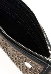 Gestreepte beige portemonnee met zilveren studs, zwarte rits en interne compartimenten. Heeft contrasterende stiksels en een kenmerkende ronde uitsparing.