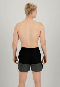 Costumi da bagno neri e grigi con una vita elasticizzata. Il design presenta un motivo a blocchi di colore, con la parte superiore nera e la parte inferiore grigia.