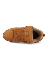 Brune suedesneaker med polstret krage, tykke snørebånd, og DC-logo på tunga og tå, sett ovenfra på hvit bakgrunn.