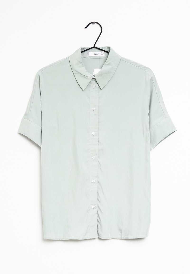 Chemise gris clair manches courtes à boutons avec col, suspendue sur un cintre noir sur fond blanc.