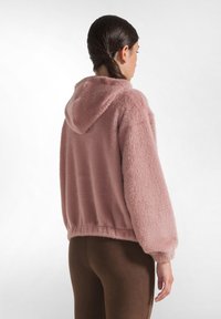 Roze donzige hoodie met een zachte textuur, een aansluitende zoom en elastische manchetten. Heeft een capuchon en een losse, relaxte silhouet.