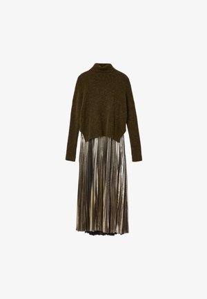 Olīvu zaķtēta augšdaļa ar augstu apkakli un īsu piegriezumu, apvienota ar sudraba plisētu metāla svārku, radot kārtaini efektu.