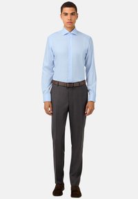 Vaaleansininen pitkähihainen kauluspaita, jossa on levitetty kaulus, yhdistetty harmaisiin teksturoituihin housuihin ja ruskeaan vyöhön, viimeistelty tummilla kengillä.