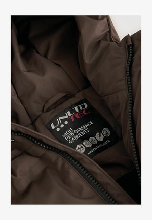 Smeđi unutarnji oblog jakne prikazuje crnu etiketu s bijelim i crvenim tekstom, koja sadrži ikone za upute za njegu i materijale.